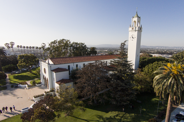 A side view of Sacred Heart Chapel with the bluff and Los Angeles skyline in the background.